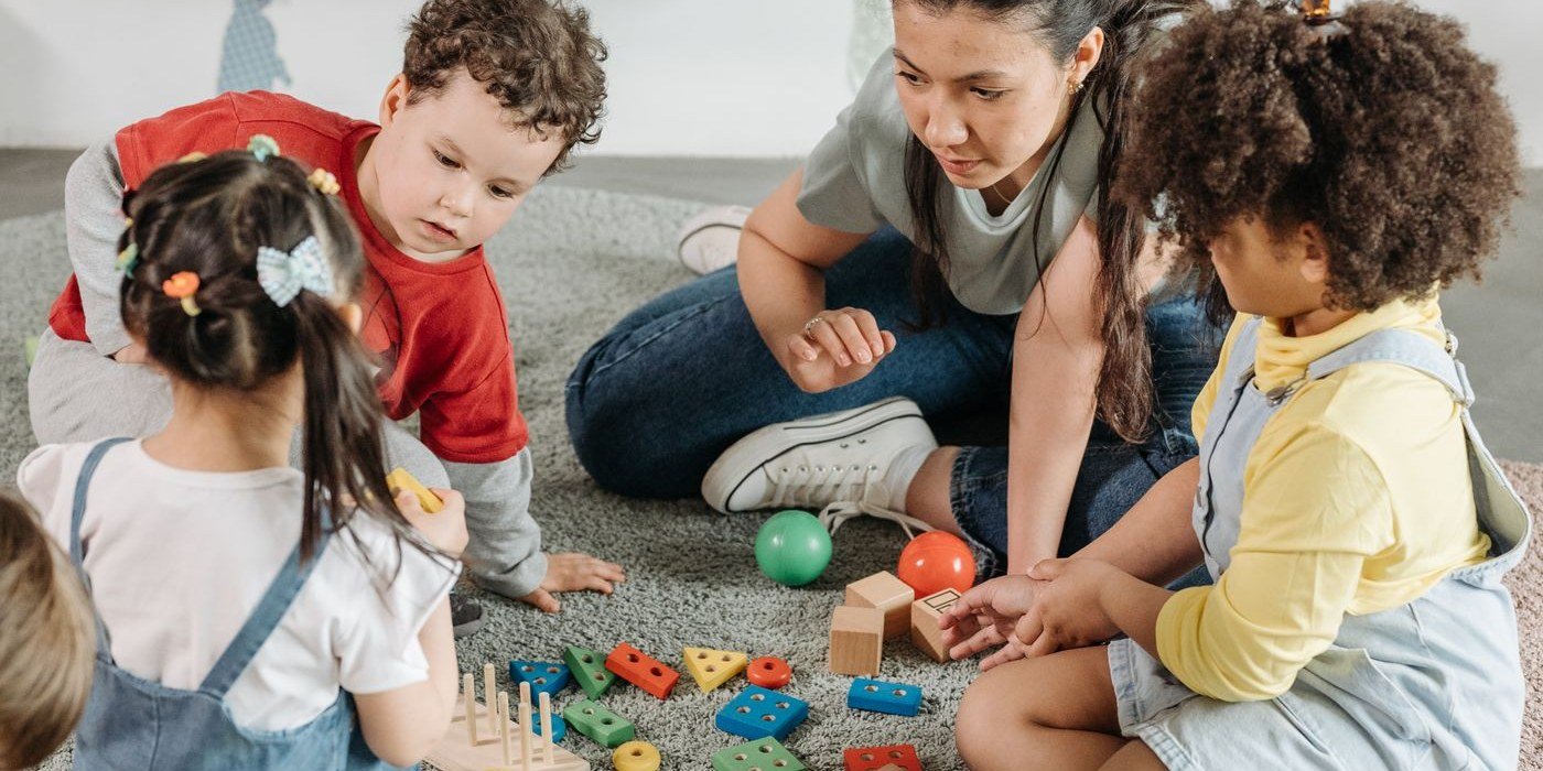 Teacher and preschool children playing and learning together