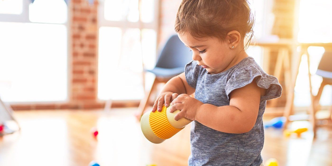 Two year old child playing with stacking toys