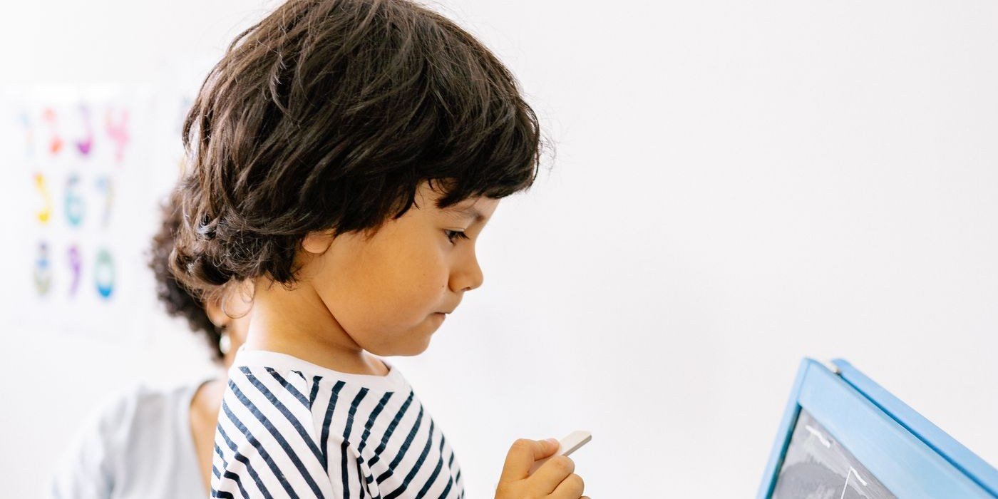 Pre-K child writing on a chalkboard
